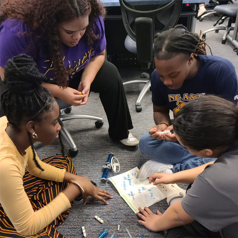  Yasmine Bush, Tasean Perkins, and Aleah McCallum work with Raekwon from NC A&T to build a solar pow